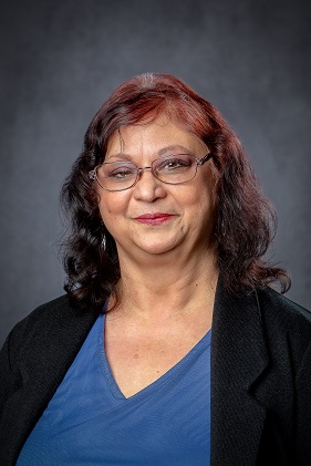 Photo of lady with flowers behind her 
