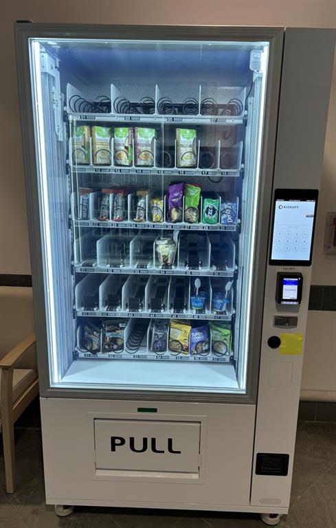 A rectangular machine with rows of food items available for purchase 